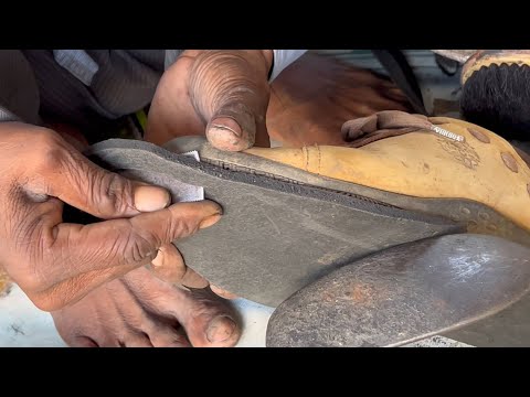 Skillful hands of a cobbler re-crafting shoes - Shoe sole repair by a road side cobbler