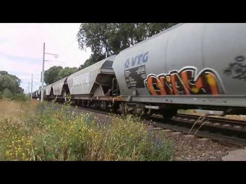 Nákladní vlak v čele černá lokomotiva letí přes žel. přejezd ve Chvalovicích, 30.6.2013