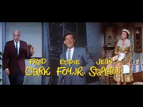 Trailer frame with Midtown signage and period dress evoking the show’s mid-century tone