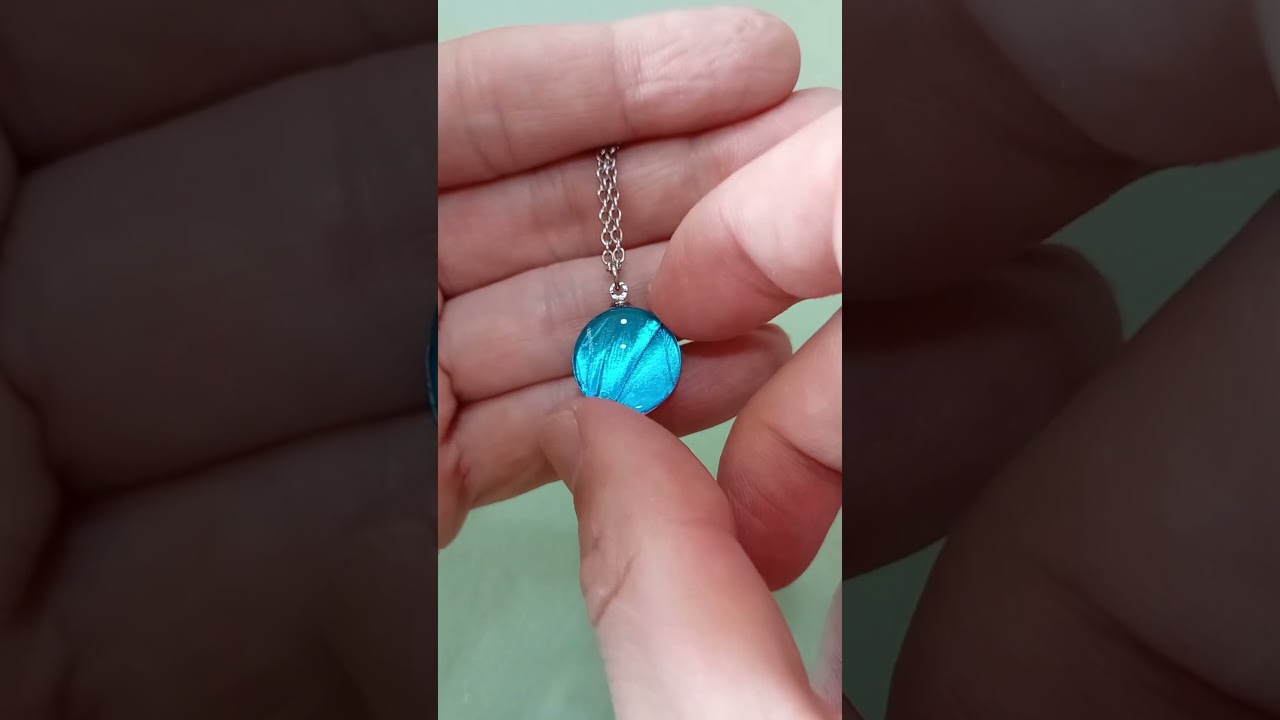 16mm real Blue Morpho butterfly wing necklace under glass lens showing vivid iridescent blue shine