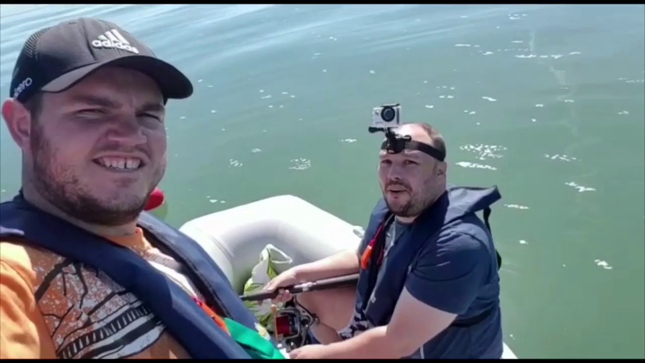 Two men in boat. One has a camera strapped to his head.
