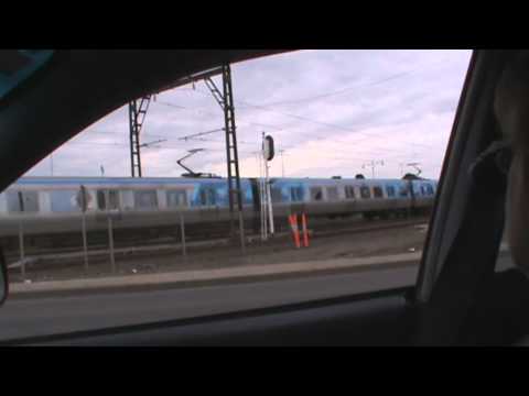 A Comeng and Siemens pass at a level crossing in Sunshine