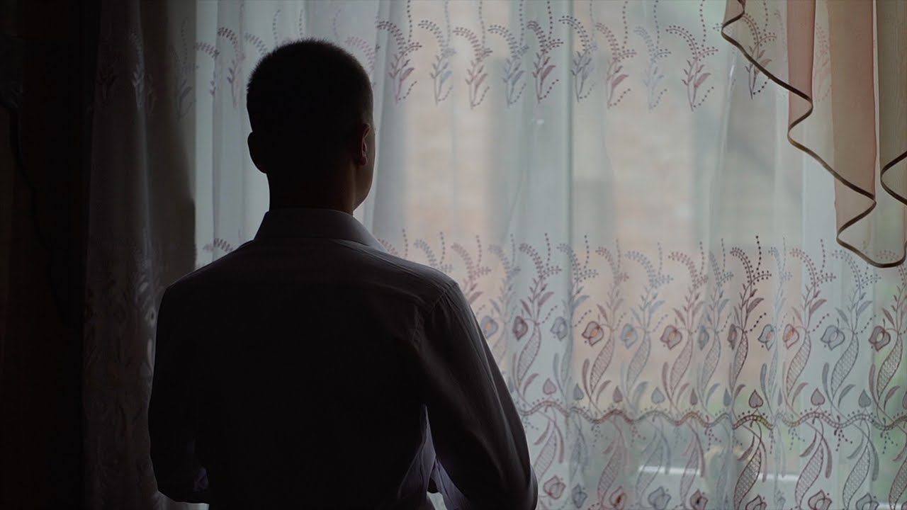 man standing in front of window