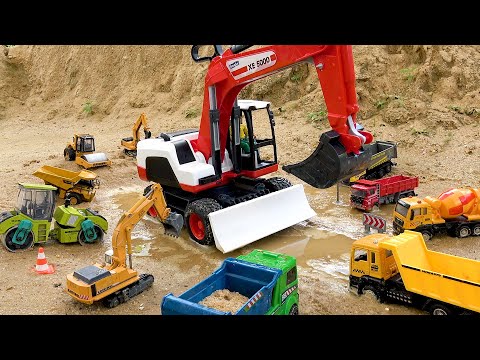 Construction vehicles work together to rescue excavator stuck in sand