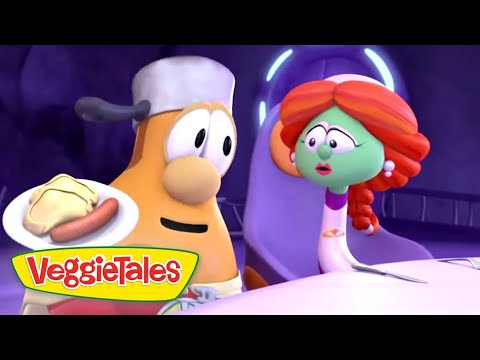 Two VeggieTales characters sit at a table; one holds a plate with a hot dog while the green, red-haired character looks on with surprise.