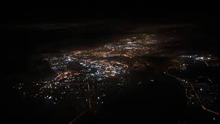 travel concept view from airplane window view on the night city black clouds