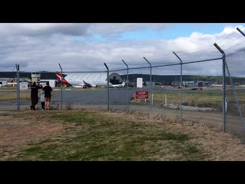 plane spotting - spectators  rush to fence to watch Qantaslink Embraer E190 takeoff