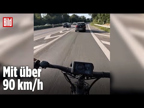 Radfahrer brettert mit E-Bike über die Autobahn