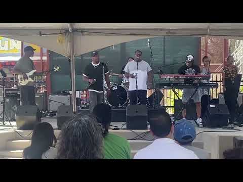 G. June performing gospel hip-hop with a band for a seated audience