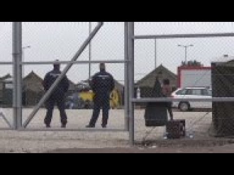 Police with dogs patrol Hungary migrant camp