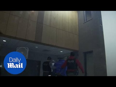 R. Kelly is led away in handcuffs after turning himself over