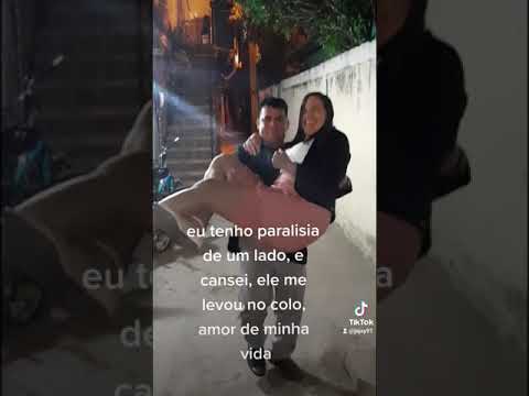 homem carrega esposa com paralisia no colo