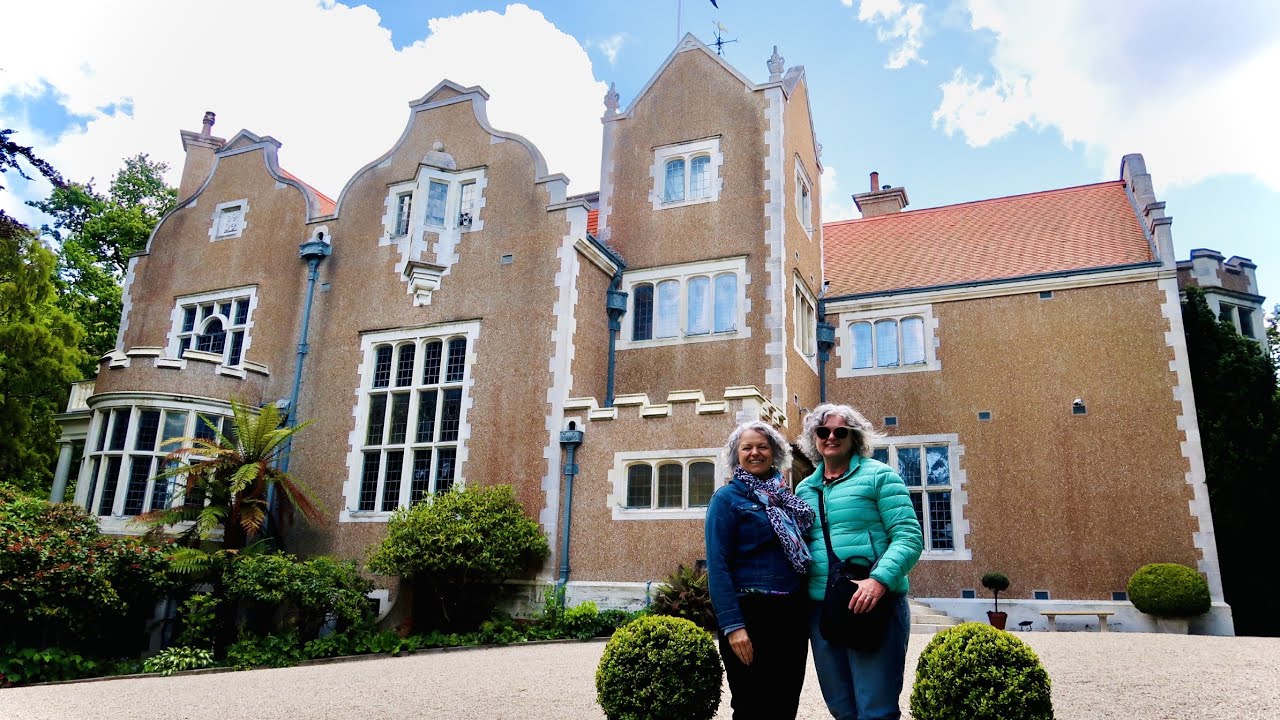 Visitors strolling through tranquil gardens framing the mansion