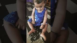 9months babygirl  playing g with puffed rice.In Amazon dress