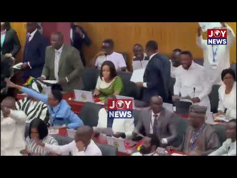 Majority MPs chanting, each holding a printed picture of Ken Ofori-Atta.