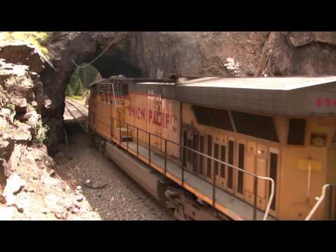 Union Pacific rock train climbs steep grade at Tunnel 29 with C60AC helper.