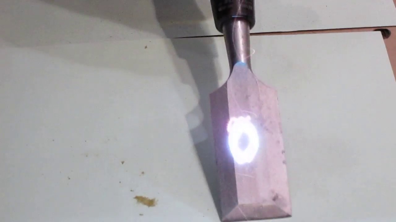 Handheld laser removing rust from a metal surface
