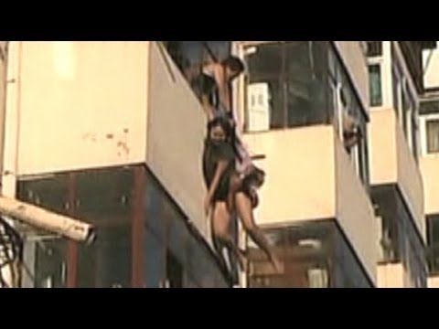 Dangling woman caught by boyfriend after falling out window