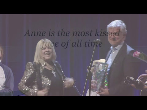 A woman and a man on a stage. A title overlay says 'Anne is the most kissed face of all time'