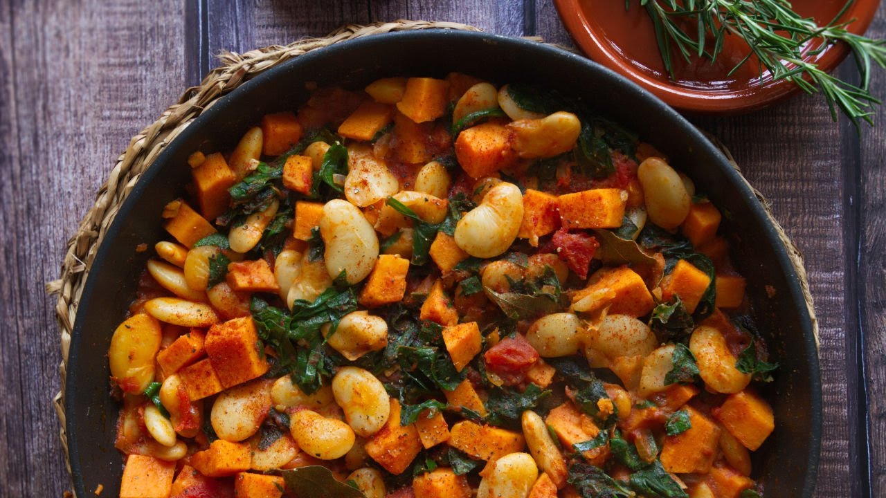 a large pan of smoky butter bean stew with sweet potato and kale