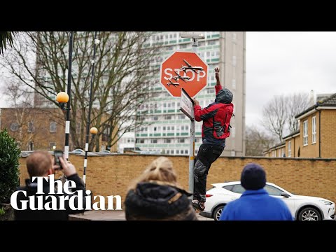 Un hombre se lleva la nueva obra de Banksy en una señal de stop en Londres