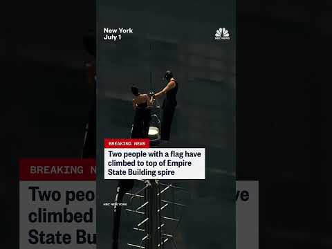 Two people climb the Empire State Building spire