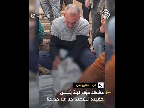 مشهد مؤثر لفلسطيني يلبس حفيده الشهيد جوارب جديدة