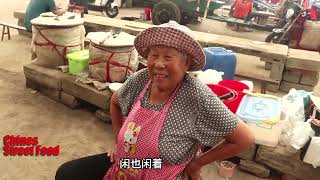 A 78 year old  woman sell snacks on the street