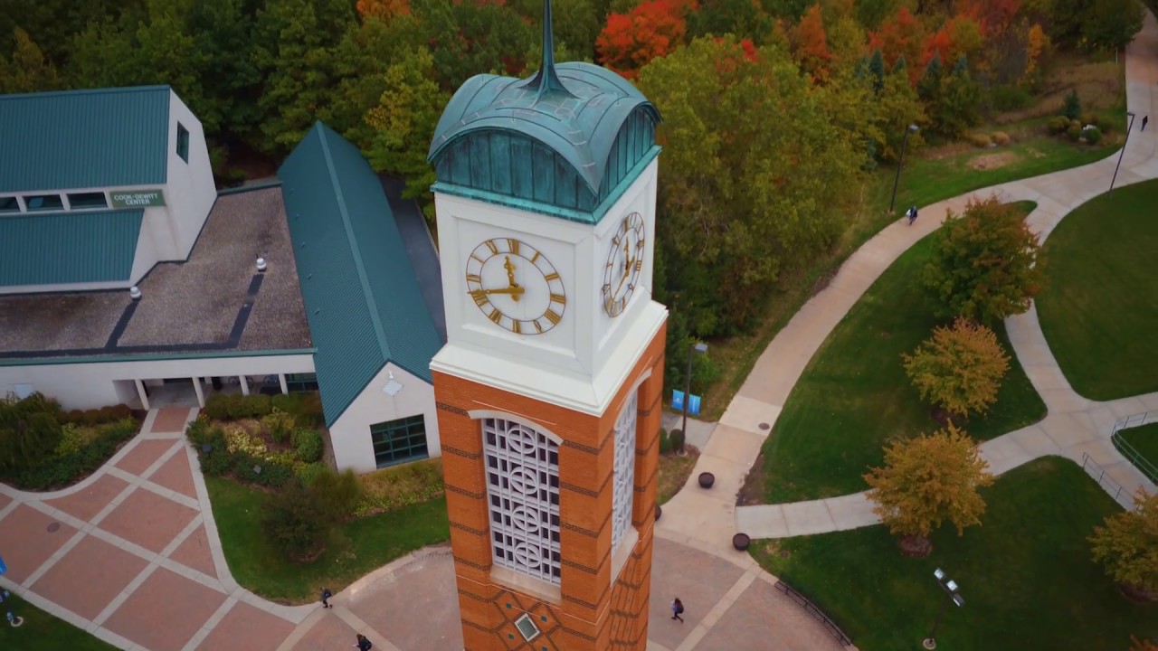 drone shot of campus, in october with red leaves on trees, the clock tower, kirkhof, and the library