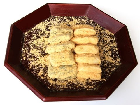 Injeolmi tteok rice cakes coated in roasted soybean flour arranged on a wooden board