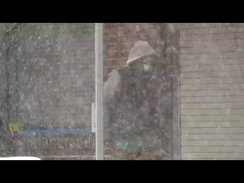 Snow falls in downtown Denver on Monday