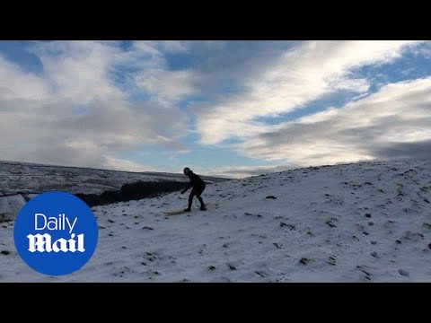 Brave man goes SNOW surfing in Yorkshire as icy weather grips UK - Daily Mail