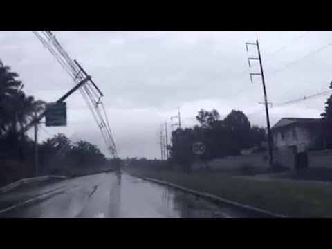 Terrifying moment electricity pylons fall onto a car during storm