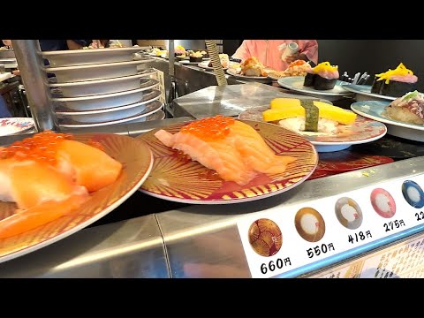 A small conveyor belt sushi restaurant at Haneda Airport with lots of sushi on the move