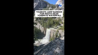 Tourists jump barrier for photo near Yosemite waterfall