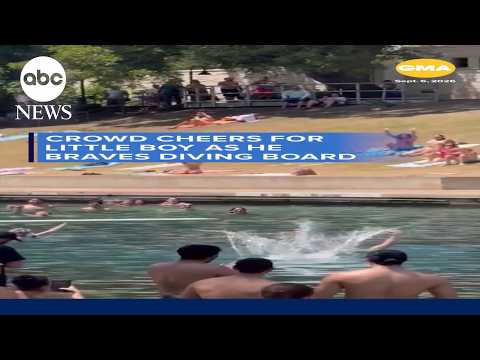 Crowd cheers for little boy as he braves diving board