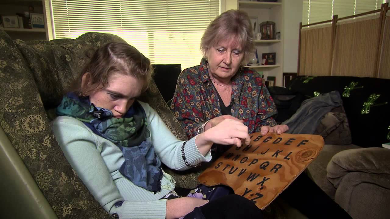 Kirsteen with her mom using an alphabet board to communicate