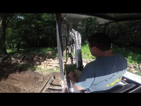 bobcat 325 mini exc. straightening out a rock wall