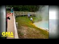 Tourist Touches Hot Spring With Hand At Yellowstone GMA