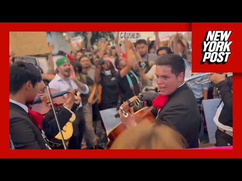 Anti-ICE protesters in downtown San Antonio sing with mariachi band