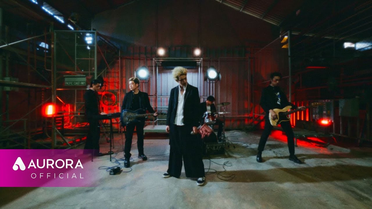 The members of 2Z performing as a band in a warehouse, from the music video for “Glorious Youth” (기세)