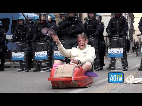 Verona, corteo contro le Olimpiadi verso l’Arsenale: manifestante sullo slittino con la maschera d