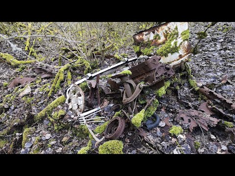 Die Reste eines Oldtimer Auto Pkw der Opel und ein altes Moped im Wald gefunden beim Wandern