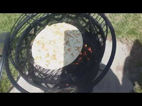 Cooking a pizza over an outdoor firepit