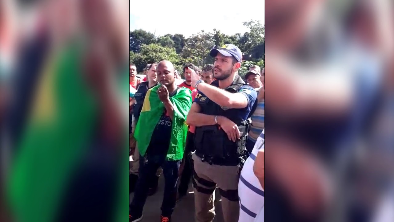 Imagem: Policial rodoviário conversa com caminhoneiros na BR-040