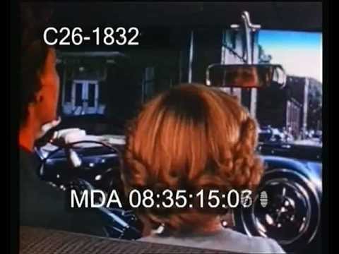 Driving along main street. Small town 1950s America. 1950s cars, trying to park