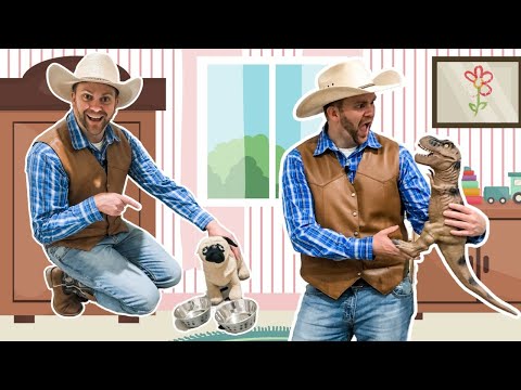 Two men dressed as cowboys in a child’s playroom, one pointing at a small pug-like plush beside metal bowls, the other holding a plastic dinosaur puppet.