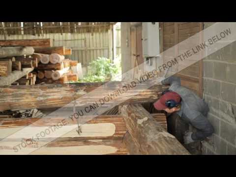 A man inspects beam house on the accuracy of the installation. Wooden house half built