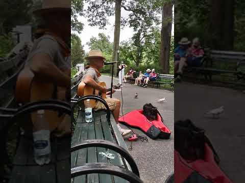 man playing Beatles songs in Strawberry Fields part of Central Park New York