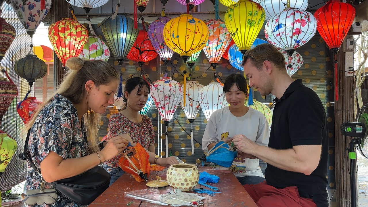 Tourists engage in lantern-making workshops, crafting vibrant creations and learning traditional Hoi An artistry.